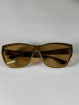 des lunettes de soleil marron posées sur une table blanche, sur fond blanc