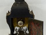a small clock with an angel on top of it