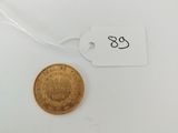 a close up of a gold coin on a white surface