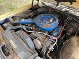 a blue engine in the trunk of an old truck
