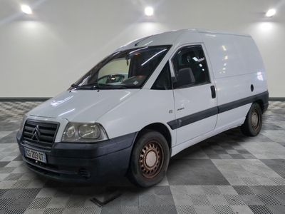 une camionnette blanche garée sur un sol en damier