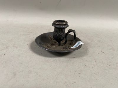 un petit plateau en argent sur lequel est posé un vase noir