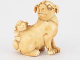une figurine en ivoire représentant un chien et un chat