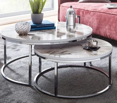 deux tables basses rondes en marbre posées sur un tapis dans un salon