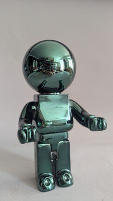 a shiny green toy that looks like a robot