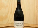 une bouteille de vin posée sur un tonneau en bois