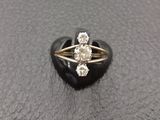 a close up of a diamond ring on a black surface