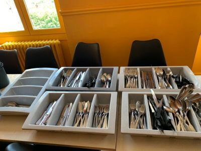 Plusieurs plateaux d'argenterie sont posés sur une table devant une fenêtre