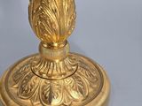 a gold vase with a flower on it on a table