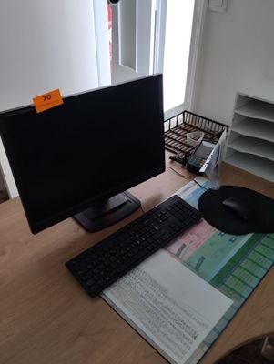 un écran d'ordinateur, un clavier et une souris posés sur un bureau