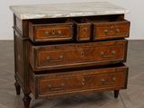 a marble top chest of drawers on a wooden table