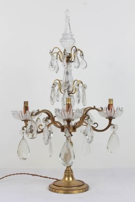 a small crystal chandelier on a table with a light on it