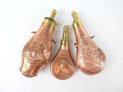 three antique copper wine bottles on a white surface