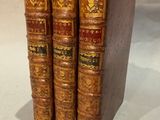three books are stacked on top of each other on a white surface