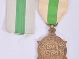 two medals and a ribbon are on a white surface