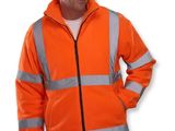 un homme vêtu d'une veste orange, debout, les mains dans les poches