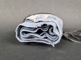 a close up of a folded pair of jeans on a black surface