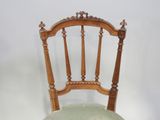 a wooden chair with a green upholstered seat