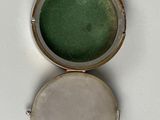 two small round lockes with a green glass in the middle