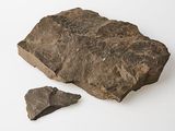 a large rock and a small piece of rock on a white surface
