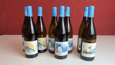quatre bouteilles de vin sont alignées sur une table