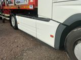 un gros camion blanc équipé d'un plateau à l'arrière