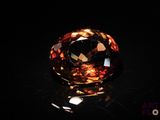a close up of a large orange diamond on a black surface