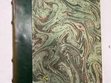un vieux livre posé sur une table recouverte de marbre