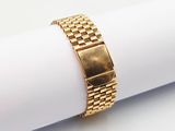 a close up of a gold watch on a napkin on a white surface