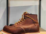 une paire de bottes Red Wing posée sur une étagère en bois