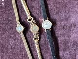 three watches are sitting on a purple cloth on a table
