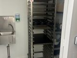 a metal rack with trays of food in a kitchen