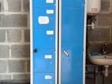 deux casiers bleus situés à côté d'un lavabo dans une pièce