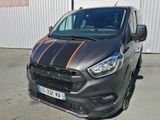une camionnette grise à rayures orange garée devant un immeuble