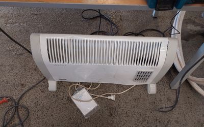 un radiateur blanc posé par terre à côté d'une table