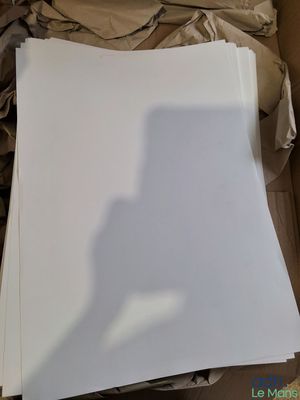 a white sheet of paper in a box with a shadow of a person