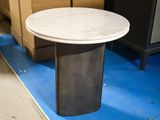 a white marble table with a black base on a blue floor