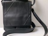 le petit sac noir est posé sur la table, avec une bandoulière