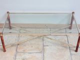 a glass coffee table with wooden legs on a tile floor