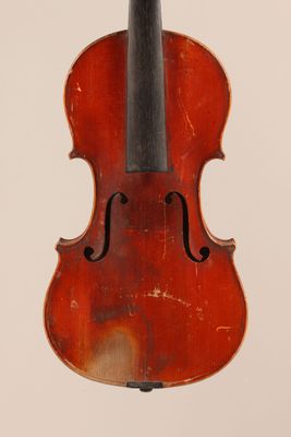 un vieux violon posé sur une surface blanche