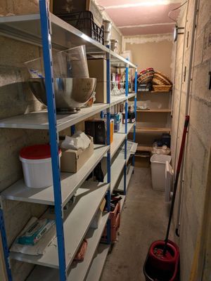 a narrow room with shelves and bins in it