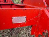 a red plow that is sitting in the grass