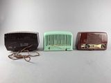 three vintage radio ' s are lined up in a row on a table