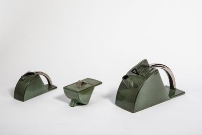 trois morceaux de métal vert posés sur une surface blanche, sur fond blanc