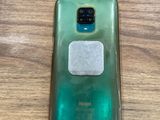 the back of a green samsung s9 with a white button on it