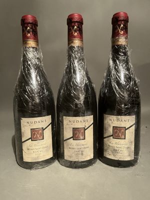 three bottles of wine wrapped in plastic sitting on a table