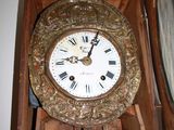 a clock that is sitting on a shelf in front of a mirror