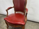 an image of a red leather chair sitting on top of a tile floor