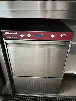un lave-vaisselle en acier inoxydable sur lequel est apposé un autocollant rouge