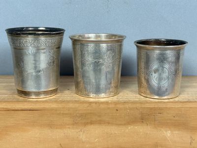 trois tasses en métal posées sur une table en bois